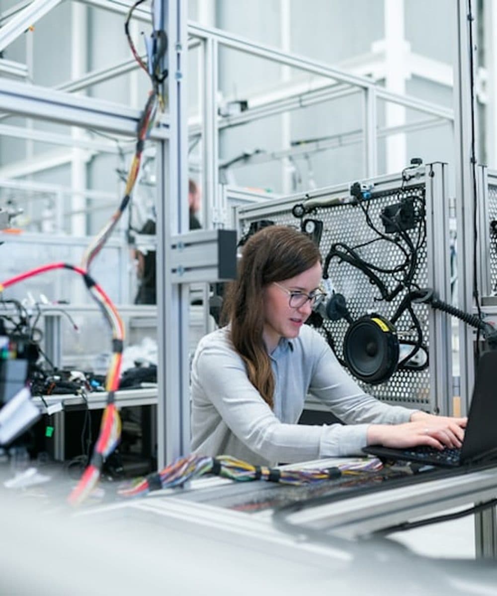 Ingeniera revisando sistemas industriales con su equipo de cómputo